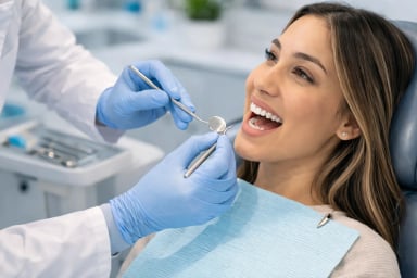Dental examination in progress with smiling patient.