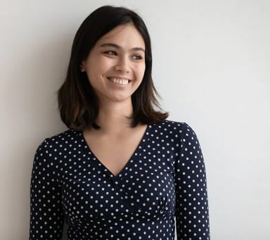Smiling woman with dark hair in a polka dot dress